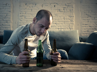 People, depression men and alcohol addiction concept. depressed man drinking alcohol at home alone