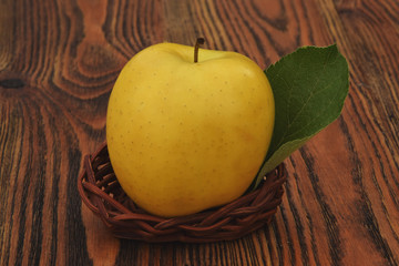  An apple in a basket with a leaf tree sign.