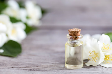 Essential jasmine oil. Massage oil with jasmine flowers on a wooden background