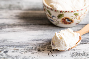 Fresh homemade mascarpone. Traditional Mascarpone cheese in wooden spoon