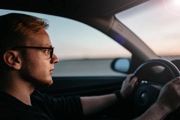 driver of the car goes to meet the sun at dawn.