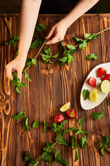lime, strawberry, mint - ingredients for making lemonade on brown wooden table. empty space for text