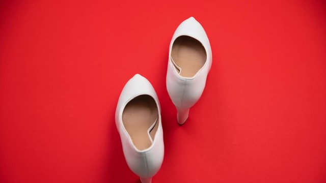 White classic pumps walking a couple steps. Uncertainty stems, walks backwards.