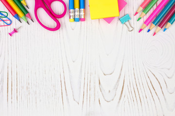 School supplies top border. Top view on a white wood background with copy space. Back to school concept.