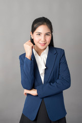 Portrait of smart  business woman in blue suit on grey background, studio shot