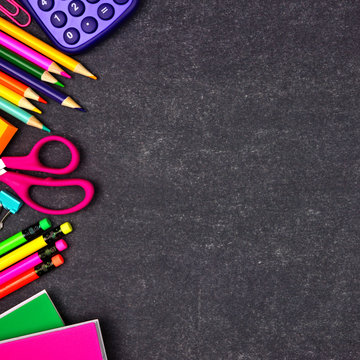 School supplies side border. Overhead view on a chalkboard background with copy space. Back to school concept.