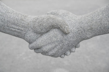 Stone handshake. Concept of cooperation, partnership, team