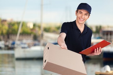 Man delivering package, holding clipboard for signature