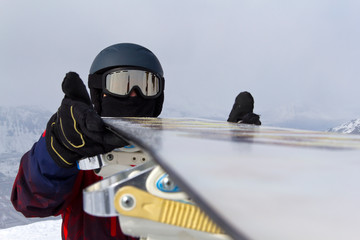 winter sports athlete checks equipment before descending from a snowy mountain in a ski resort