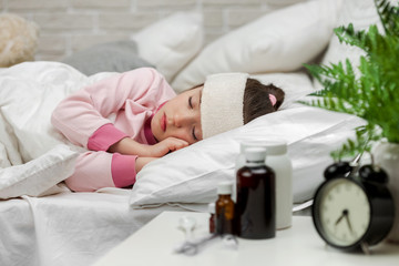Sick little child girl lying in bed with thermometer. Cold flu season