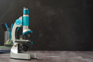 Back to school. Microscope isolated on black background. Studying biology at school laboratory.