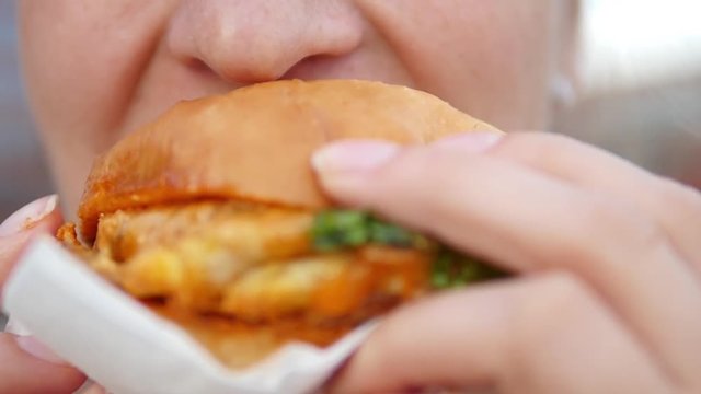 Closeup Of Woman Mouth Eating Vegan Burger. Closeup.