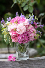 Blumenstrauß mit Hortensienblüten und Rosen in Pink in Glasvase