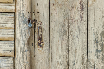 background of old wooden door with padlock in an abandoned country house close up