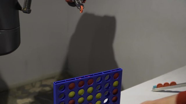 The man and the robot put the chips in the sockets.