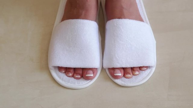 Closeup top view of two female legs wearing new clean white sleepers. Real time full hd video footage.