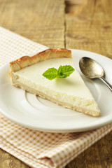 Slice of plain cheesecake on wooden table. Homemade dessert.