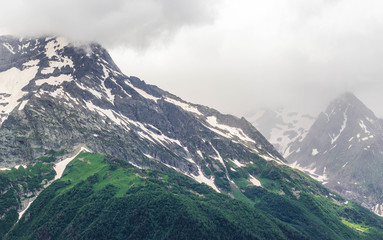 Dombay mountain range in the Caucasus in summer, snow-capped peaks and green mountain slopes