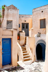 Fototapeta premium Classic Greek architecture with blue doors and shutters, Santorini, Greece, city of Pyrgos, Europe. Travel concept, details of the one of the most beautiful travel destinations of the world
