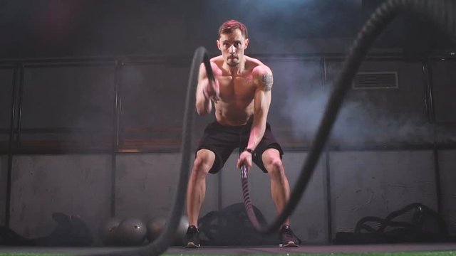 Fat Burning Battle Ropes Workout is a sure fire way to strip the last bit of fat off for summer. Cute Training Man. Slow motion
