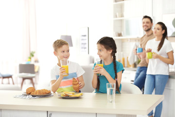 Happy family having breakfast together in kitchen