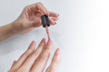 Close up of woman fingers is doing nail polish