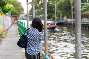 Pretty female photographer taking a picture of Chao Phraya River