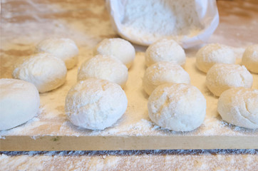 concept of baking bread. round soft dough for baking. Flour board. cook cheesecakes..bag with white flour in the background. soft focus.