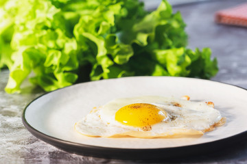 Fried eggs in white plate and coffee for breakfast on a light background on a sunny day.