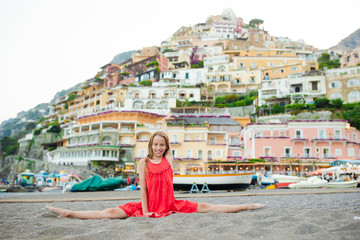 Fototapeta na wymiar Adorable little girl on warm and sunny summer day in Positano town in Italy