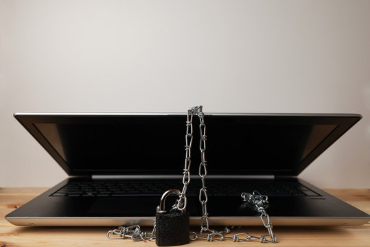 A computer with a lock is on the wooden table