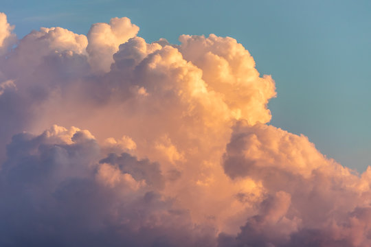 Close up view of beautiful colored dramatic cumulus fluffy clouds on blue sky at sunset background