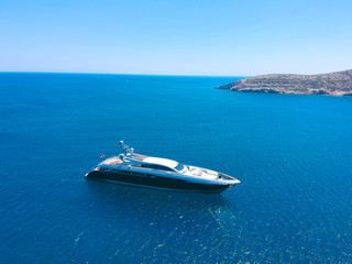 Aerial view of luxury private yacht in the blue sea during summer. Big yacht sailing in open waters. Santorini, Greece. 