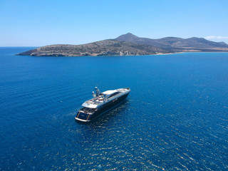 Aerial view of luxury private yacht in the blue sea during summer. Big yacht sailing in open waters. Santorini, Greece. 