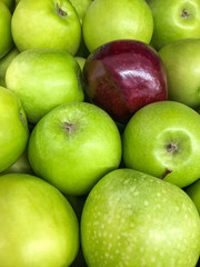 red apple in the middle of green apples