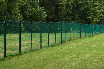 Fences with current on a green field