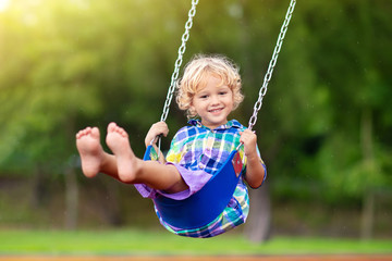 Child on playground. swing Kids play outdoor.
