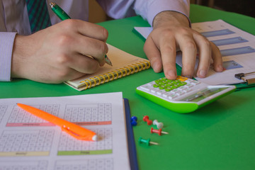 Businessman hand using calculator, accounting concept. hands with pencil, notebook and Calculator on table