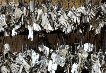 Close up of countless silver key blanks hanging on rings at wall for duplication - Bangkok, Thailand