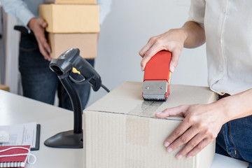 Young entrepreneur SME receive order client and working with packaging sort box delivery online market on purchase order and preparing package product, Small business parcel for shipment