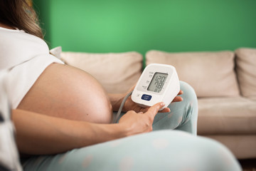Pregnant pressure . Pregnant woman controls blood pressure pressure gauge wrist