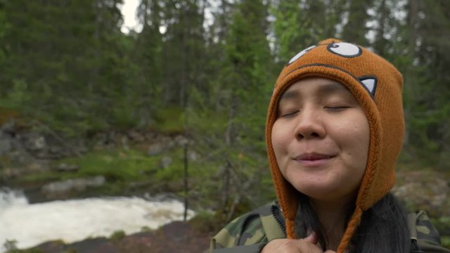 Close shot of a woman doing funny faces in a forest in Norway.