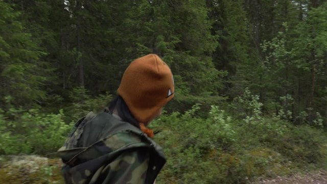 Woman walking in the woods in slow motion and smiling.