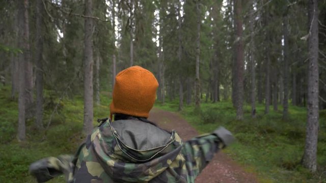 Woman walking in slow motion in a forest of Norway.