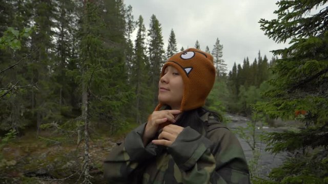 Woman sending a kiss to the camera in a forest of Norway.