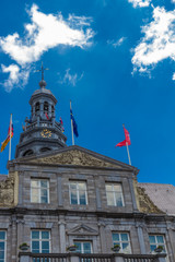 Close up of the Maastricht City hall and bell tower built in the 17th century in a classicist baroque style and was designed by Pieter Post against an amazing blue sky with dramatic clouds
