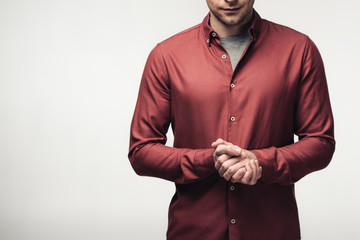 cropped view of man with clenched hands isolated on grey, human emotion and expression concept