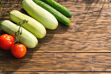 Tomatoes, cucumbers and squash on wooden boards
