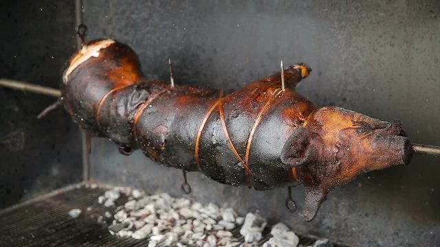 Whole roasted pork cooked with fire and charcoal, roast beef detail, Food street festive of traditional European cuisine. Roast suckling pig is cooked