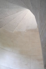 Spiral white stone staircase view from down up.